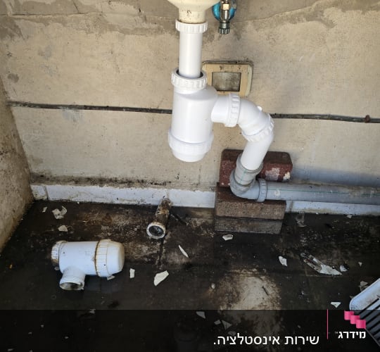 כיור עם צנרת שבורה ומים על הרצפה